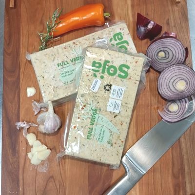 Paquets de tofu et quelques légumes sur une table